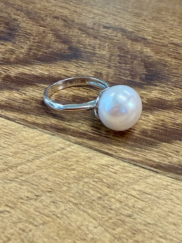 A sterling silver ring with a single round white pearl